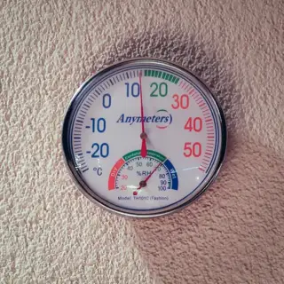 A hygrometer hanging on the wall, to help a homeowner monitor the humidity in the home.