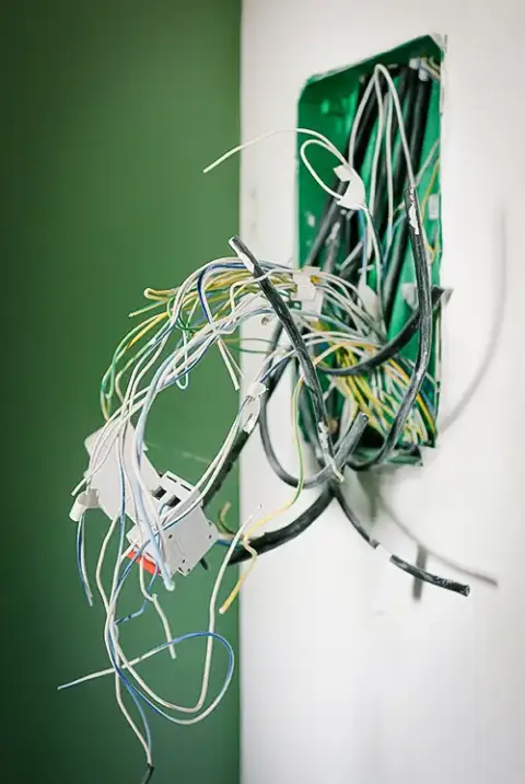 A jumble of wiring protruding from the wall.