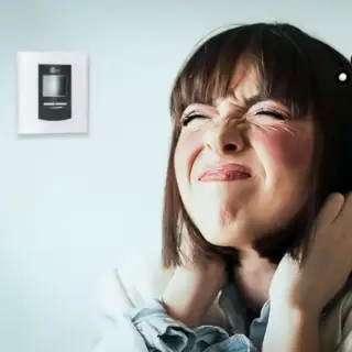 A lady pulls her hair in frustration over a blank thermostat.