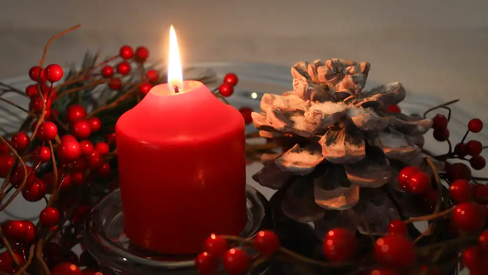 A pretty holiday candle surrounded by cranberries.