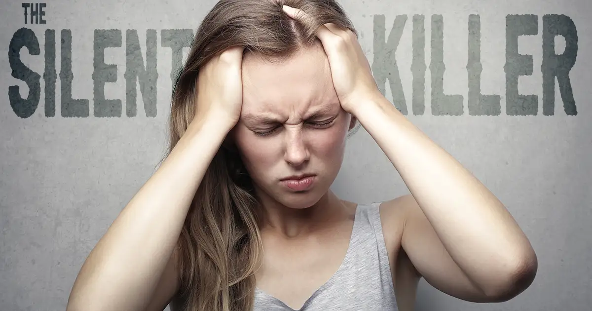 Woman holding her head because of intense headache caused by the silent killer, Carbon Monoxide