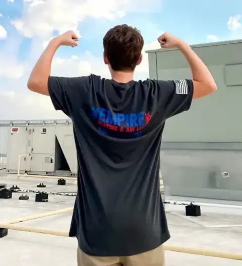 We are Empire Heating & Air, as a crew member flexes with a branded t-shirt.