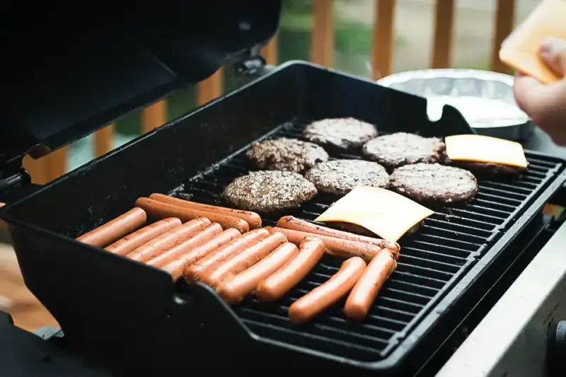 Grilling burgers and hot dogs on a hot summer Texas evening.