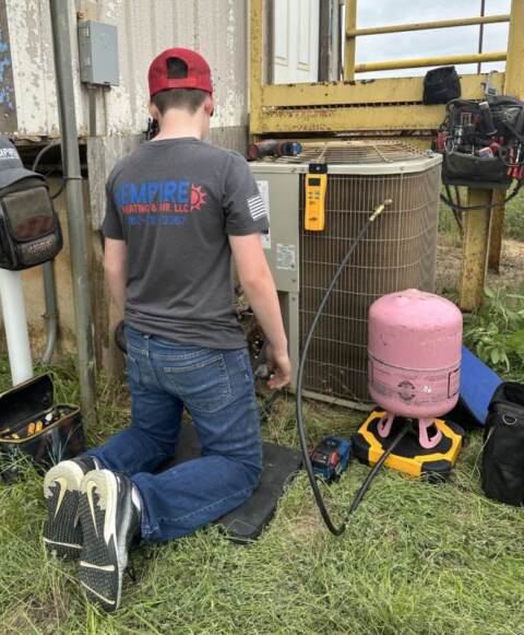 A technician from Empire Heating & Air performs preventive maintenance for a customer's HVAC